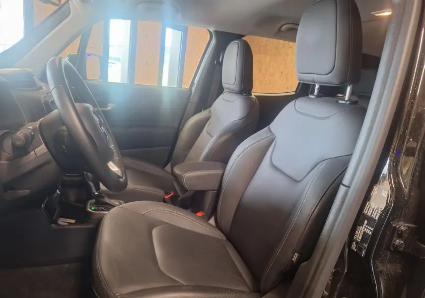 Vue intérieure côté gauche du Jeep Renegade 2024 noir, sièges avant en cuir noir avec coutures apparentes.