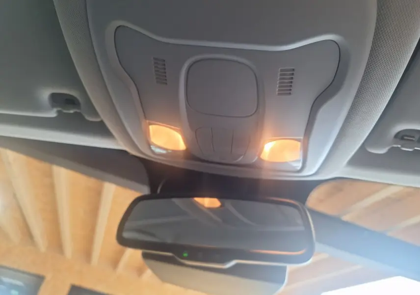 Vue intérieure du plafonnier avec éclairage allumé et rétroviseur d'une Jeep Renegade noire 2024.