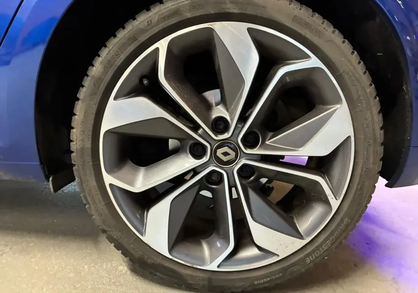 Gros plan sur la jante alliage 18 pouces au design moderne de la Renault Mégane bleu 2019.