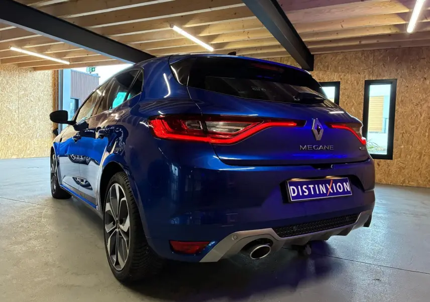 Vue 3/4 arrière droite d'une Renault Mégane 1.7 BlueDCI 150 GT Line bleu, avec feux LED et jantes alliage 18 pouces.
