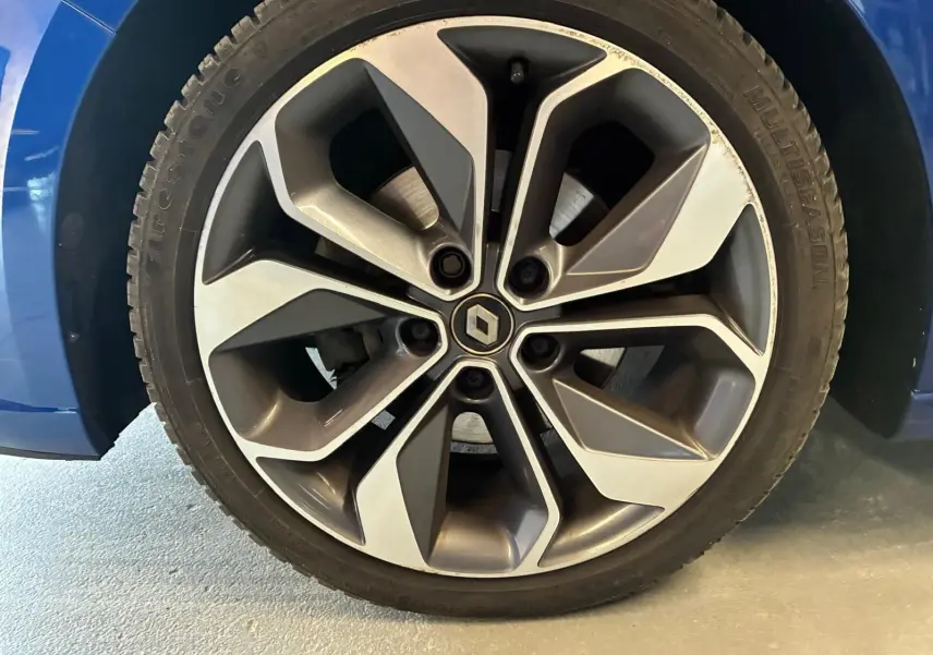Gros plan sur la jante alliage bicolore grise et argentée d’une Renault Mégane bleu 2019.