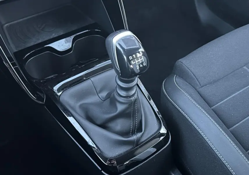 Gros plan sur le levier de vitesses manuel noir et la console centrale d’une Citroën C3 2025, intérieur sobre.