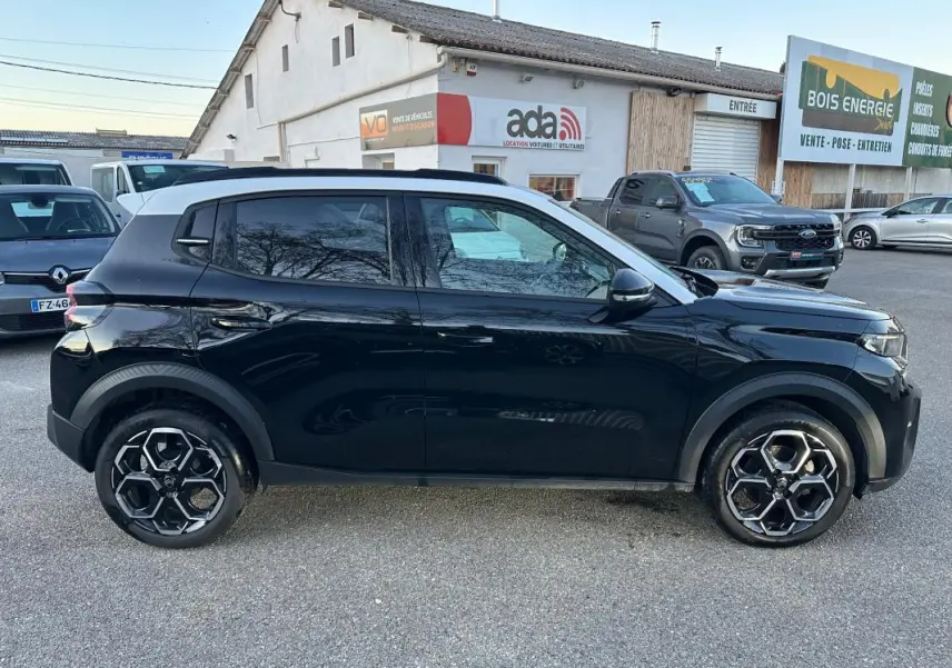 Profil côté gauche d'une Citroën C3 noire 2025 avec jantes alliage 17 pouces et toit blanc contrasté.