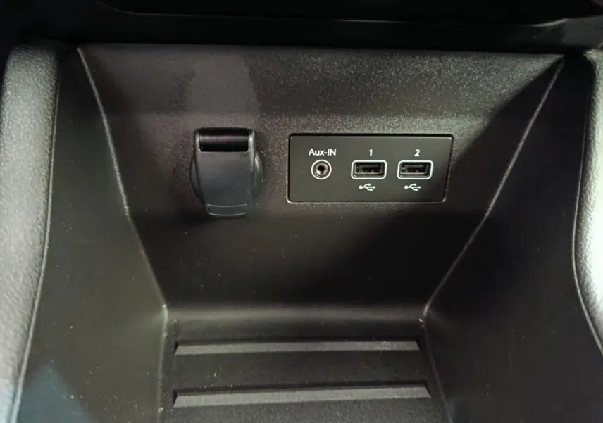 Gros plan sur la prise 12V, port Aux-IN et deux ports USB dans le compartiment avant de la Renault Clio Business Blue dCi 100.