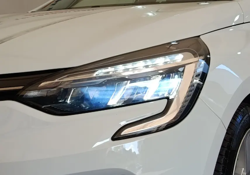 Gros plan sur le phare avant droit LED d’une Renault Clio Business Blue dCi 100 blanche de 2022.