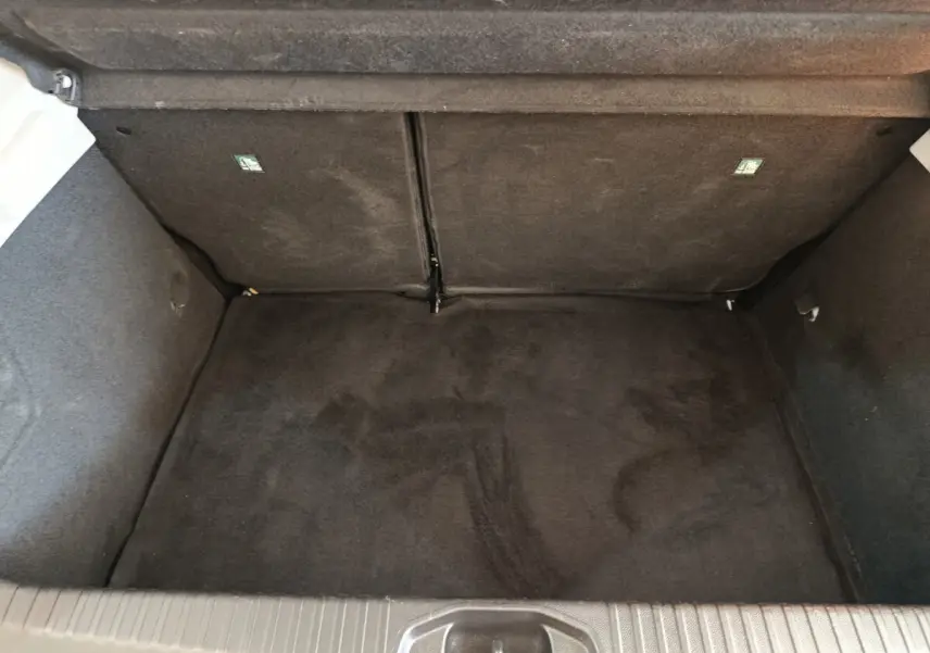 Coffre vide de Renault Clio Business Blue dCi 100 blanc, vue intérieure en plongée montrant la moquette noire.