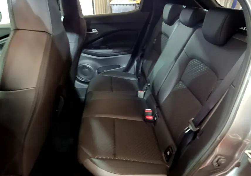 Vue côté droit de la banquette arrière en cuir noir du Nissan Juke Hybrid 143 Business+ 2023 avec portière ouverte.