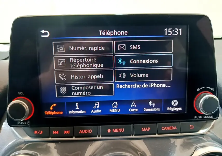 Écran tactile central du Nissan Juke Hybrid 2023 affichant le menu téléphone avec commandes audio et caméra en dessous.