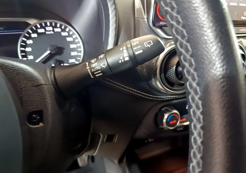 Gros plan sur la commande d’essuie-glace côté gauche du tableau de bord noir du Nissan Juke Hybrid 2023.