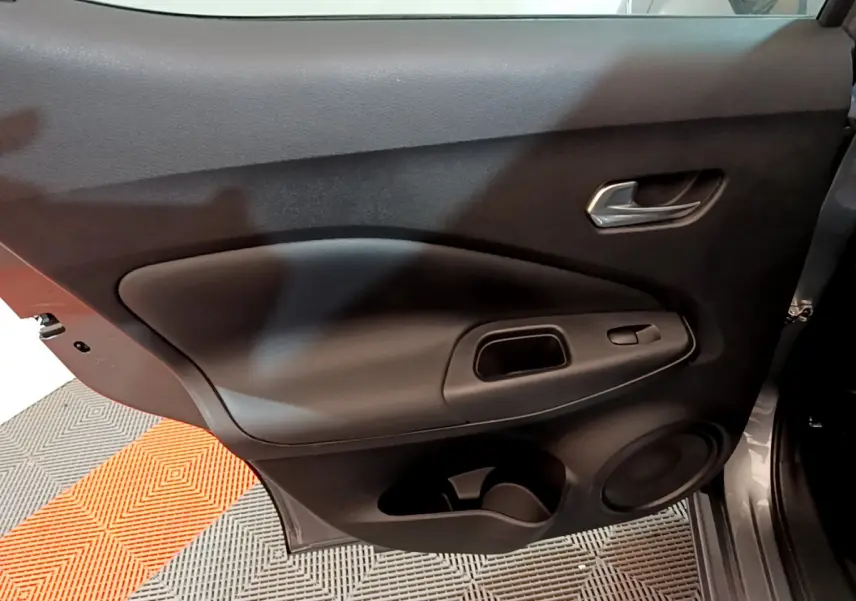 Porte arrière côté gauche noire du Nissan Juke Hybrid 143 Business+ 2023 avec poignée et commande de vitre intégrée.