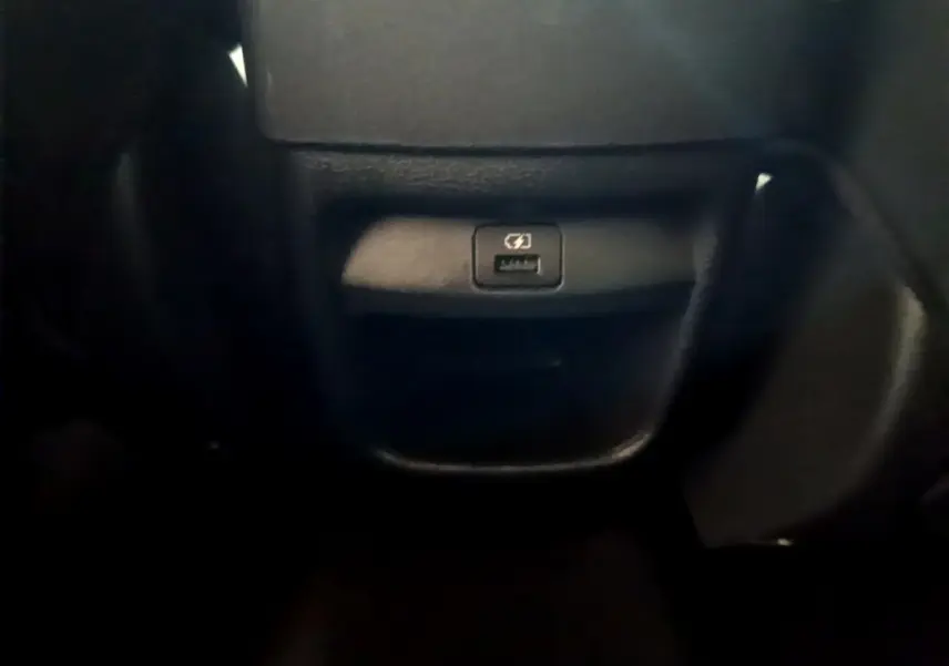 Prise USB de recharge rapide en gros plan dans l'habitacle du Nissan Juke Hybrid 143 Business+ gris foncé 2023.