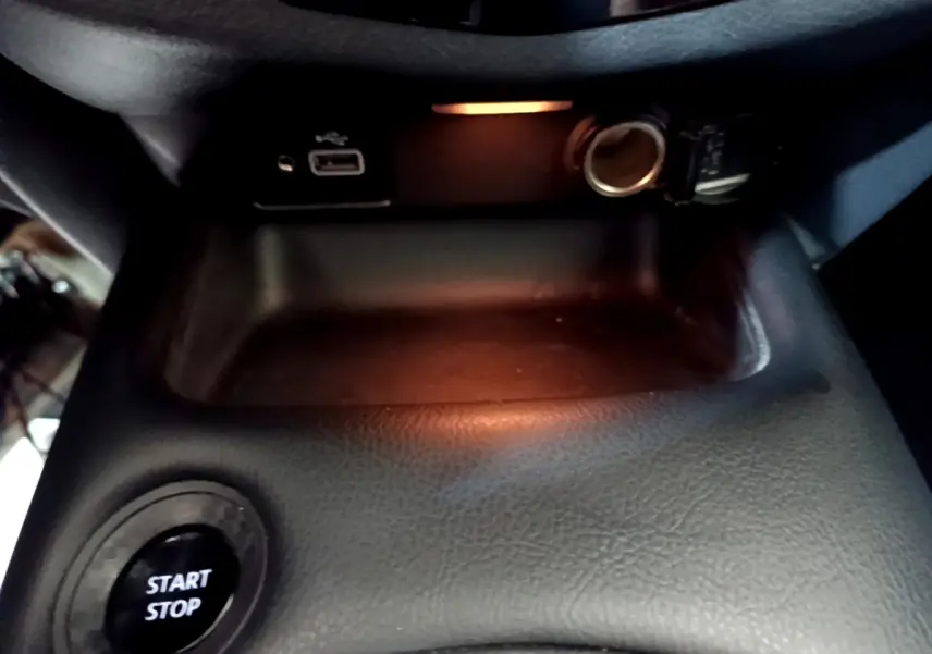 Bouton démarrage Start/Stop et prise USB avec allume-cigare dans le rangement central du Nissan Juke Hybrid 2023.