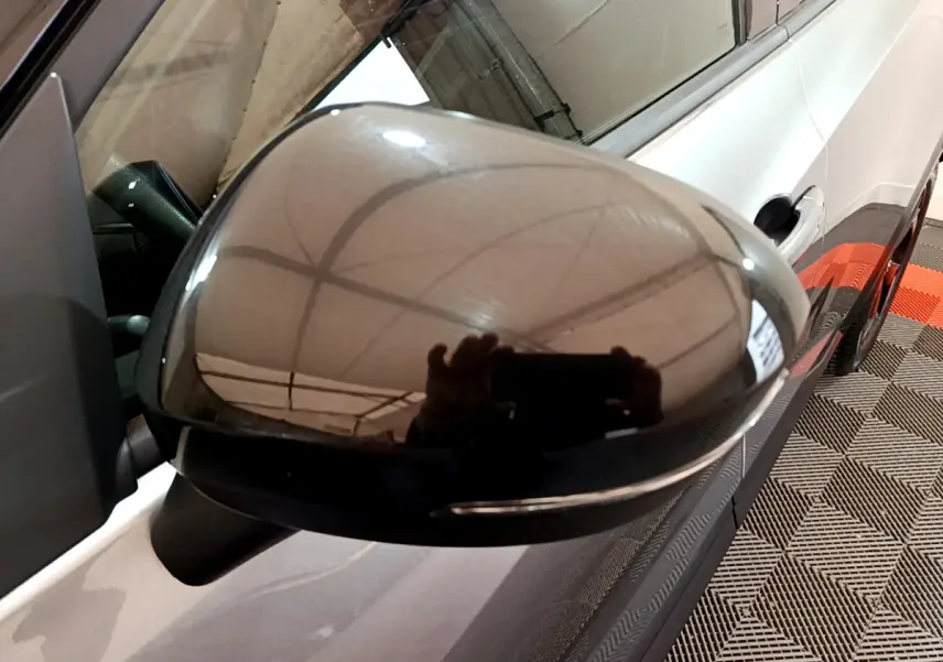 Rétroviseur droit noir brillant du Nissan Juke Hybrid 143 Business+ gris foncé, vue rapprochée sur la portière.