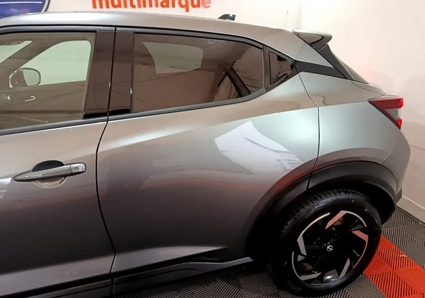 Vue latérale droite du Nissan Juke Hybrid 143 Business+ gris foncé, mettant en valeur la ligne de caisse et la jante noire design.