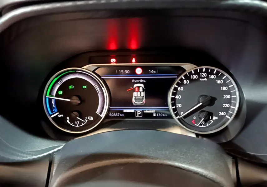 Vue rapprochée du combiné d'instruments numérique et analogique du Nissan Juke Hybrid 143 Business+ affichant alertes et jauges.