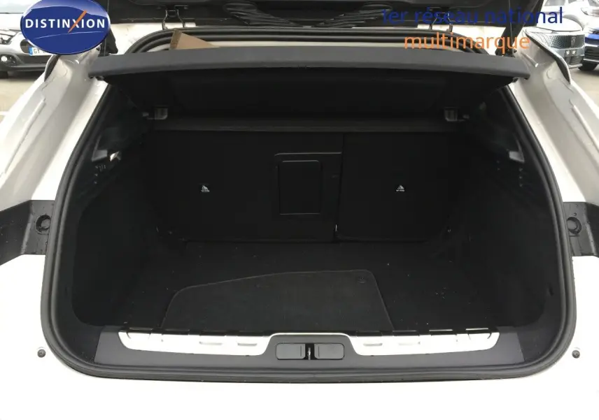 Coffre ouvert vu de l'arrière d'une DS4 2024 Eph chrystal, montrant l'espace de chargement noir et la plage arrière.