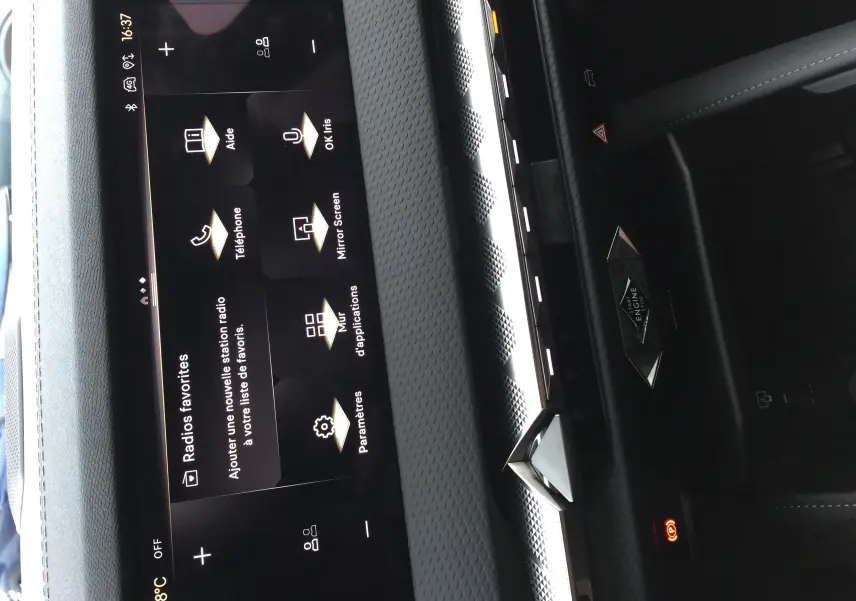 Vue rapprochée de la console centrale noire du DS4 2024 avec écran tactile et bouton démarrage stylisé diamant