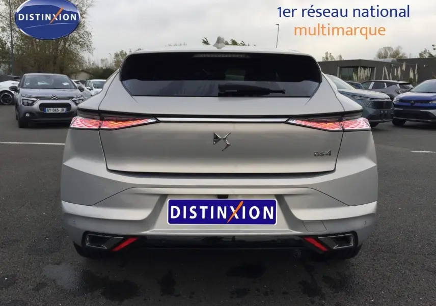 Vue arrière d'une DS4 2024 couleur Eph Crystal, avec feux arrière allumés et logo DS bien visible.