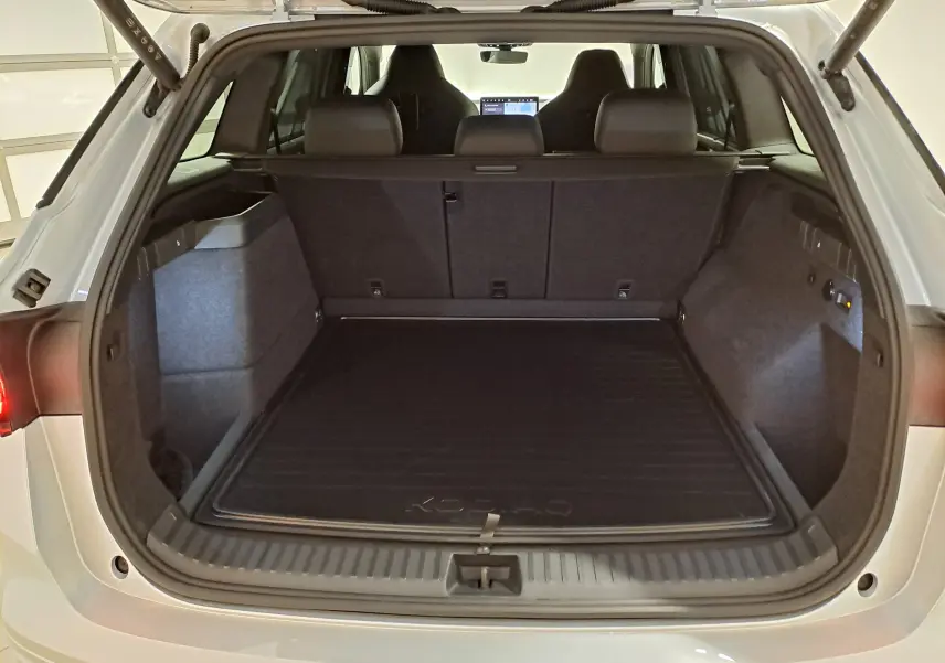 Coffre ouvert du Skoda Kodiaq gris argent, vue arrière montrant l'espace de chargement et la banquette arrière.