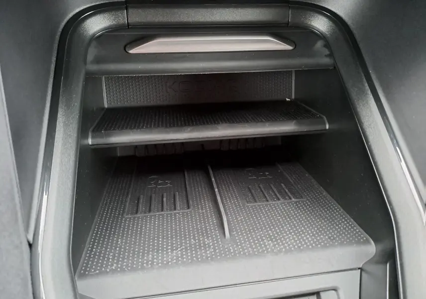 Gros plan sur le rangement central intérieur du Skoda Kodiaq avec surface antidérapante et logo KODIAQ visible.