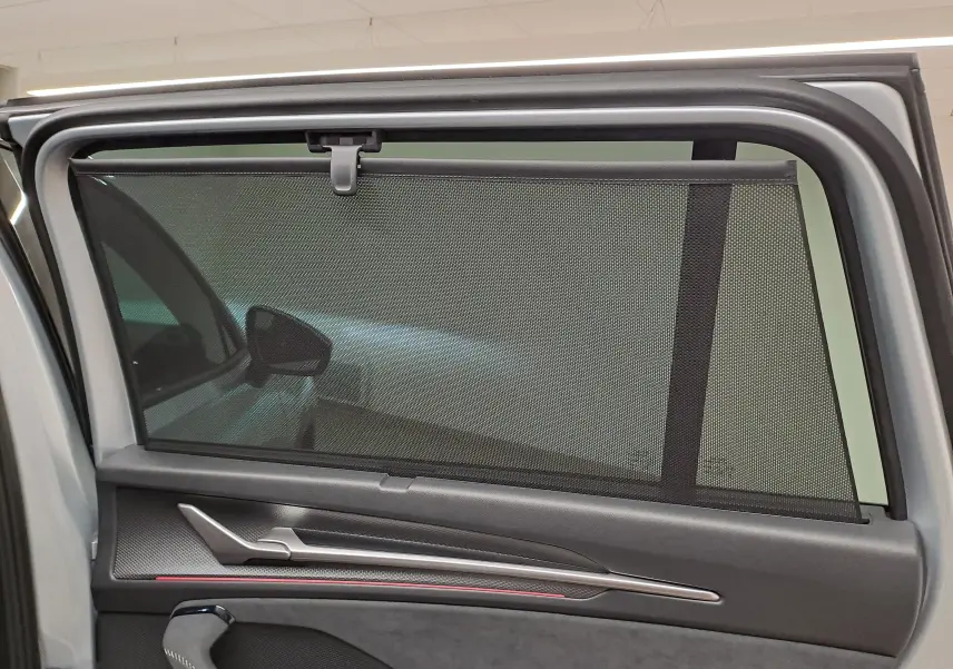 Vue intérieure sur la porte arrière gauche du Skoda Kodiaq gris argent, avec pare-soleil intégré et garniture noire.