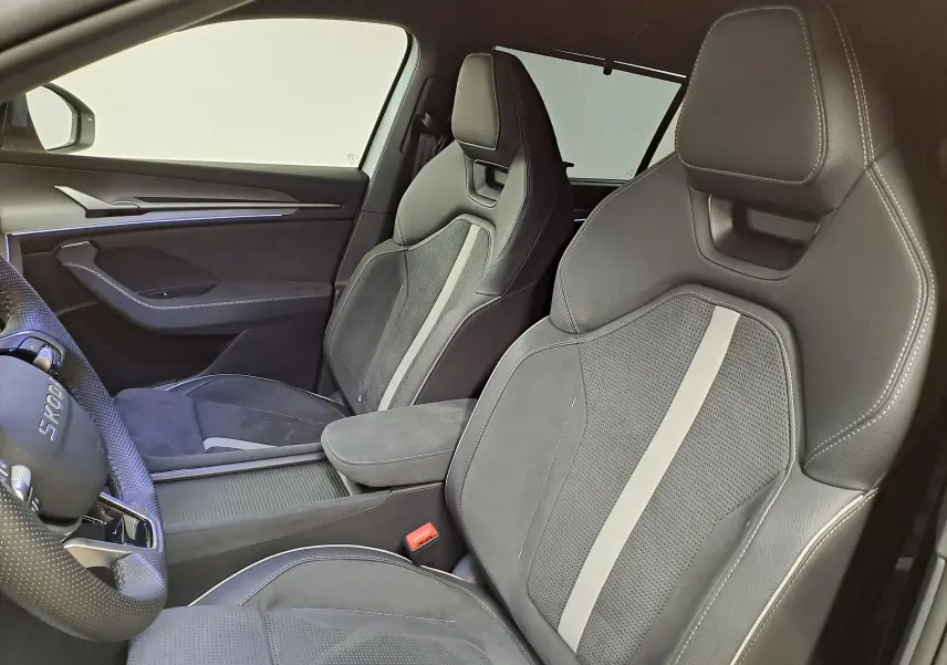 Vue intérieure côté gauche du Skoda Kodiaq 2025, sièges sport en cuir et alcantara gris avec surpiqûres blanches.