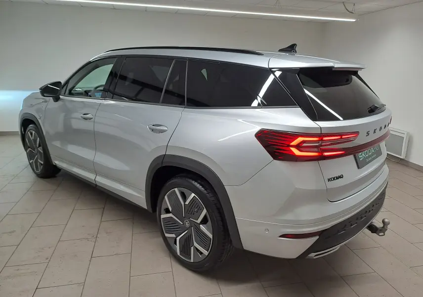 Vue 3/4 arrière droite du Skoda Kodiaq gris argent avec jantes 20 pouces et crochet d'attelage pivotant visible.