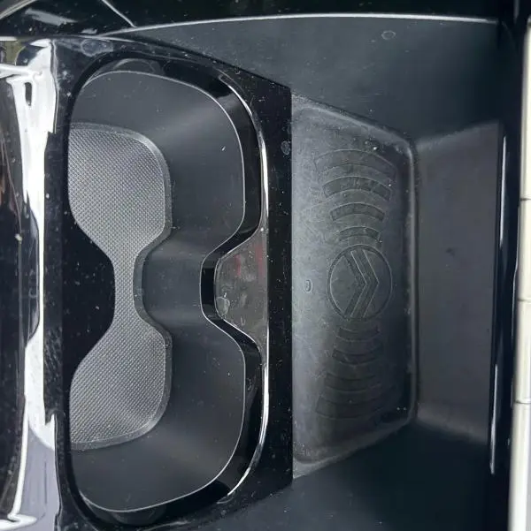 Gros plan sur le compartiment central avant d'une Citroën C3 gris 2025, avec logo Citroën et espace porte-gobelets.