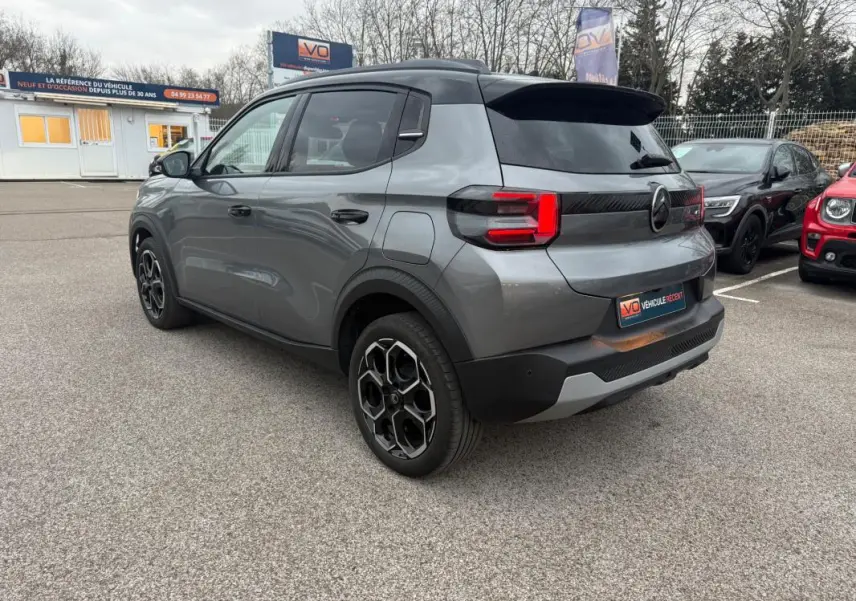 Citroën C3 Turbo 100 ch gris vue 3/4 arrière droit avec jantes alliage 17 pouces et barres de toit noires.