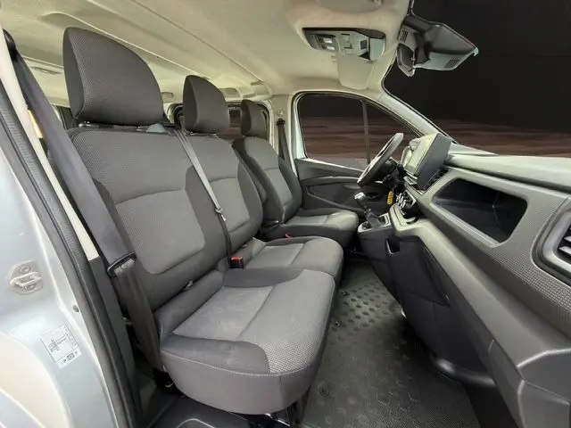 Intérieur du Renault Trafic Combi L2 2022 en gris platine, vue côté conducteur montrant sièges tissu noirs et tableau de bord.