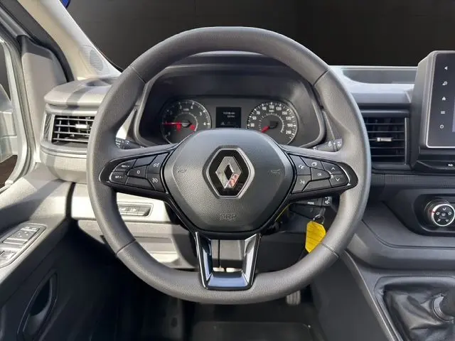 Vue centrée sur le volant noir du Renault Trafic Combi 2022, avec tableau de bord et commandes visibles en arrière-plan.