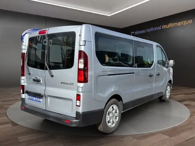 Vue 3/4 arrière droite d’un Renault Trafic Combi gris platine, avec portes arrière vitrées et jantes acier.