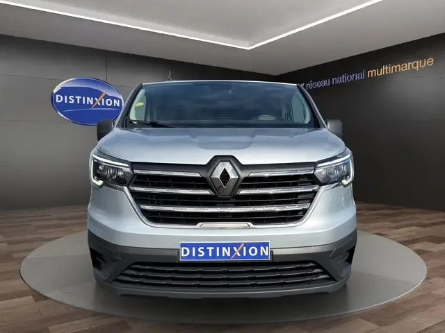 Vue frontale d’un Renault Trafic Combi gris platine 2022 avec calandre noire et logo Renault proéminent.