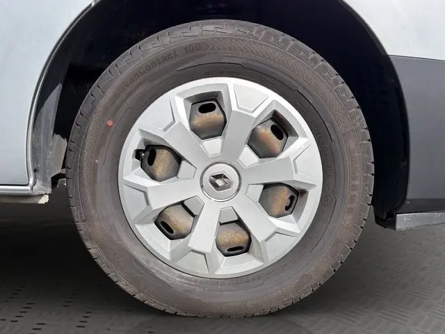 Gros plan sur la roue arrière droite d’un Renault Trafic Combi gris platine, mettant en valeur le pneu et l’aile du véhicule.
