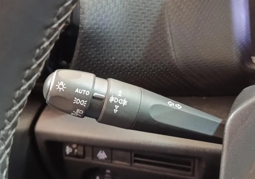 Gros plan sur la commande des feux et clignotants dans l’habitacle d’une Citroën C4 gris foncé, version 2022.