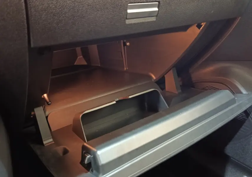 Vue rapprochée de la boîte à gants ouverte dans l’habitacle noir d’une Citroën C4 gris foncé 2022.