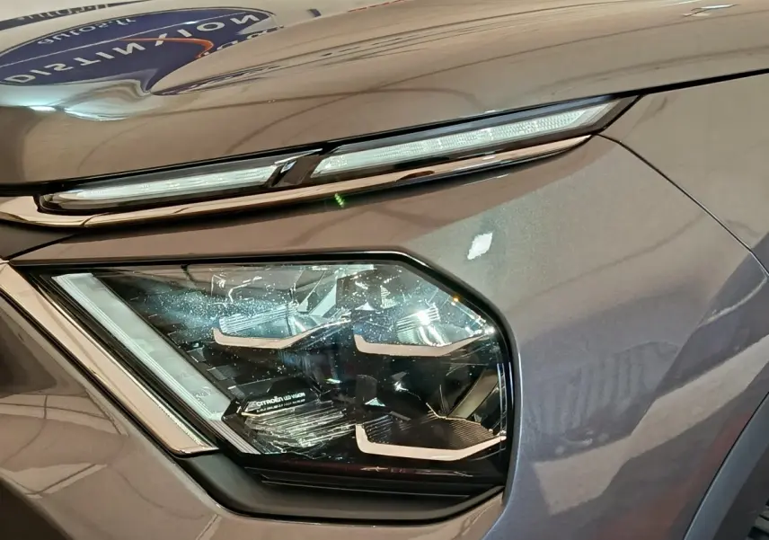 Gros plan sur le phare avant gauche d'une Citroën C4 gris foncé, soulignant son design LED moderne.