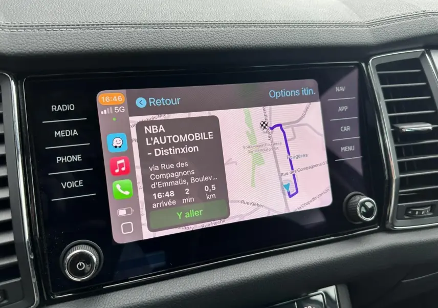 Écran tactile central du Skoda Kodiaq blanc glacier 2024 affichant la navigation avec itinéraire et options.