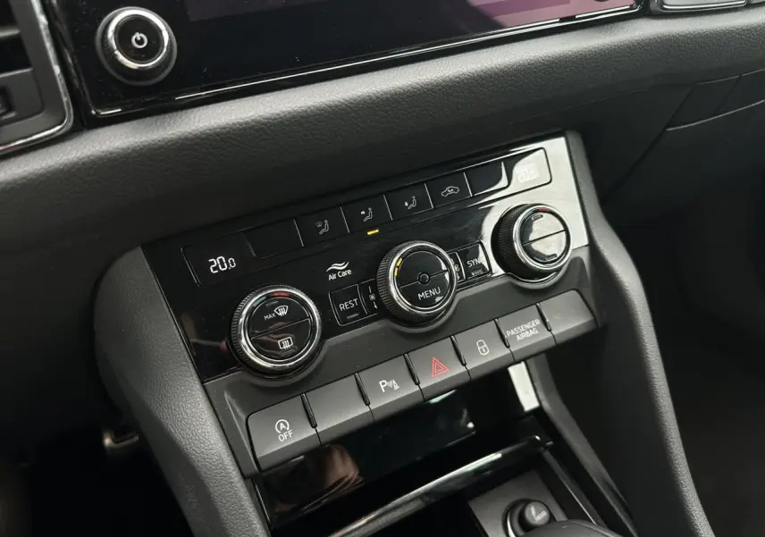 Panneau de commande de la climatisation bi-zone et boutons de sécurité dans l'habitacle du Skoda Kodiaq blanc Glacier 2024.