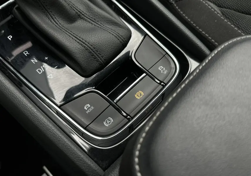 Gros plan sur la console centrale noire du Skoda Kodiaq 2024, avec levier de vitesses automatique et boutons de contrôle.