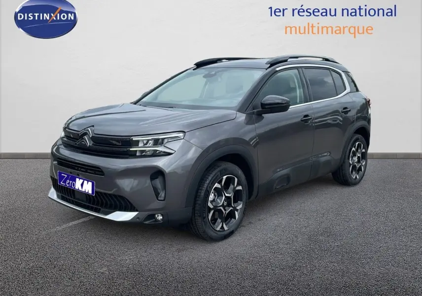 Vue 3/4 avant du Citroën C5 Aircross gris platinium métal avec toit noir et jantes biton distinctives.