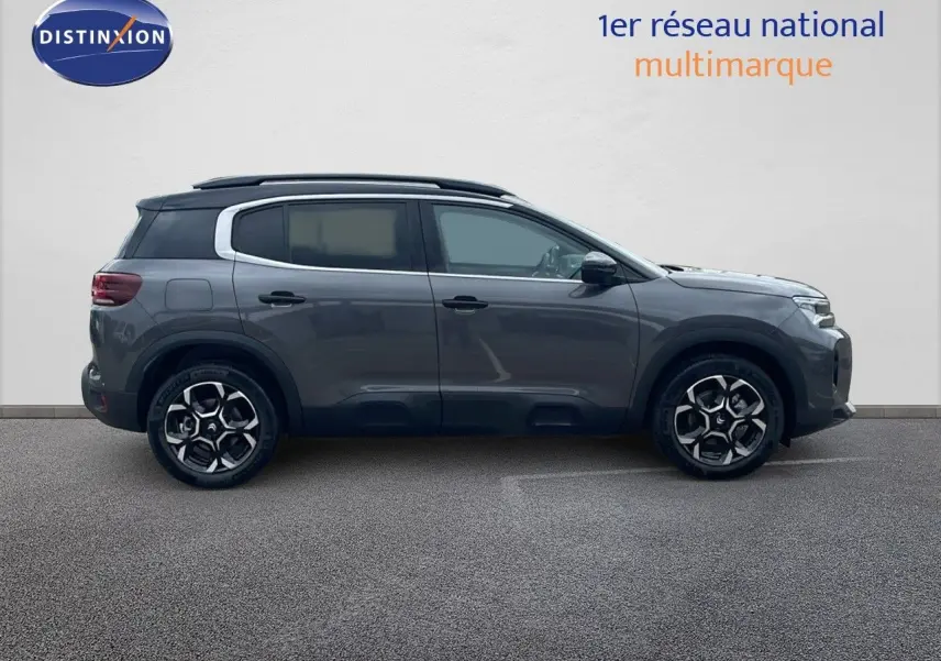 Profil côté droit d'un Citroën C5 Aircross 2025 gris platinium métal avec toit noir et jantes biton.