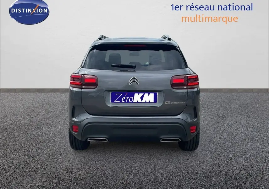 Vue arrière d'un Citroën C5 Aircross gris platinium avec toit noir, mettant en valeur ses feux et double sortie d'échappement.