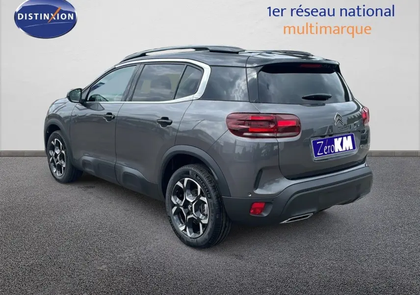 Vue 3/4 arrière droite du Citroën C5 Aircross 2025 gris platinium métal avec toit noir et jantes biton.