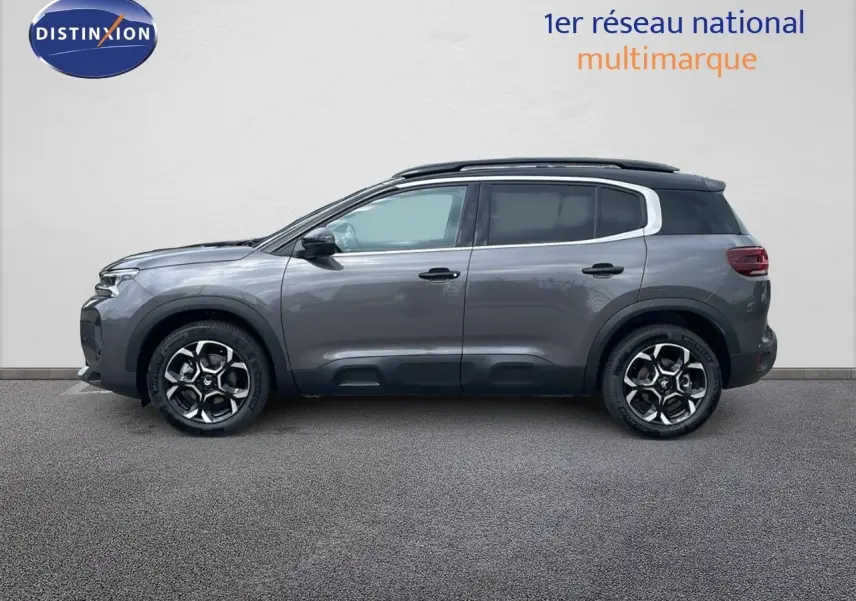 Profil côté gauche d'un Citroën C5 Aircross 2025 gris platinium avec toit noir et jantes biton 18 pouces.