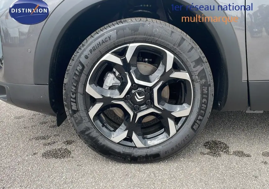 Gros plan sur la roue avant gauche du Citroën C5 Aircross gris platinium avec jante alliage bicolore et logo Citroën central.