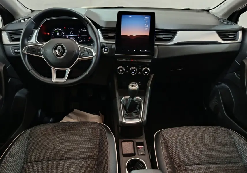 Vue frontale de l'intérieur du Renault Captur techno TCe 90 2024, avec tableau de bord numérique et écran tactile vertical.