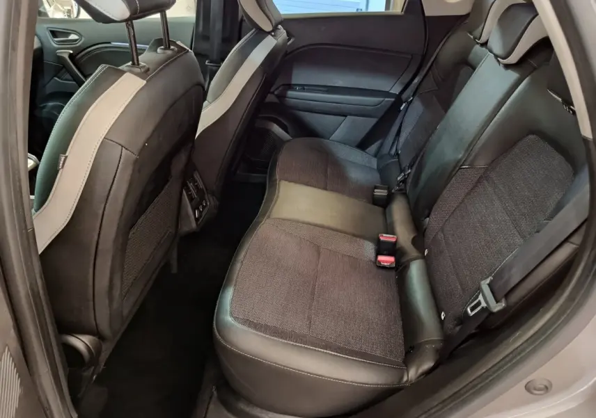 Vue côté droit de la banquette arrière en tissu et cuir noir dans un Renault Captur Techno TCe 90 gris foncé 2024