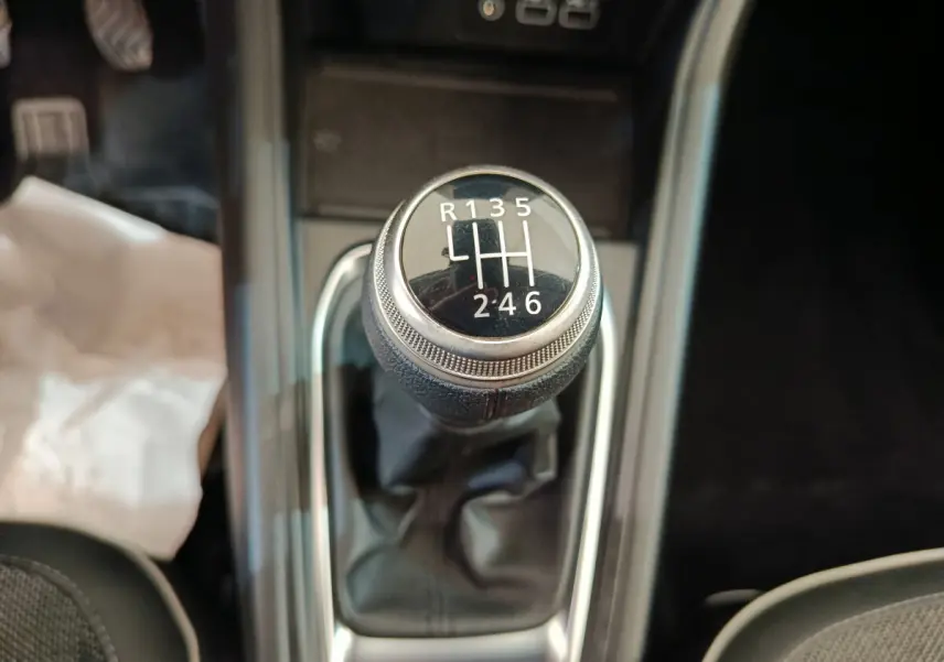 Gros plan sur le levier de vitesses manuel noir du Renault Captur Techno TCe 90 gris foncé, intérieur moderne.