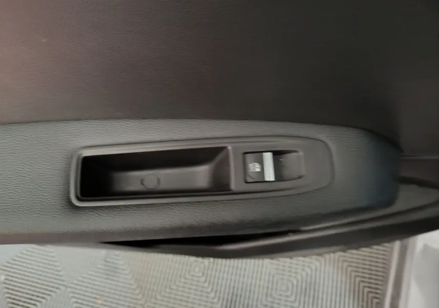 Gros plan sur la commande de lève-vitre côté conducteur dans une Renault Captur gris foncé 2024.